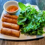Crispy vegan egg rolls (cha gio) served with fresh herbs at Saigon Vegan in Garden Grove, CA