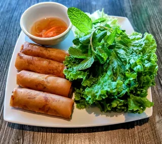 Crispy vegan egg rolls (cha gio) served with fresh herbs at Saigon Vegan in Garden Grove, CA