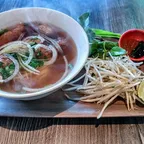 Bowl of vegan pho noodle soup with rice noodles, vegan chicken and beef, mushrooms and tofu at Saigon Vegan in Garden Grove, CA