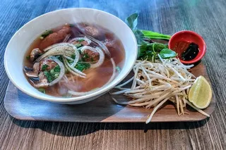 Bowl of vegan pho (Royal Noodle Soup) with rice noodles, vegan chicken and beef, mushrooms and tofu at Saigon Vegan in Garden Grove, CA